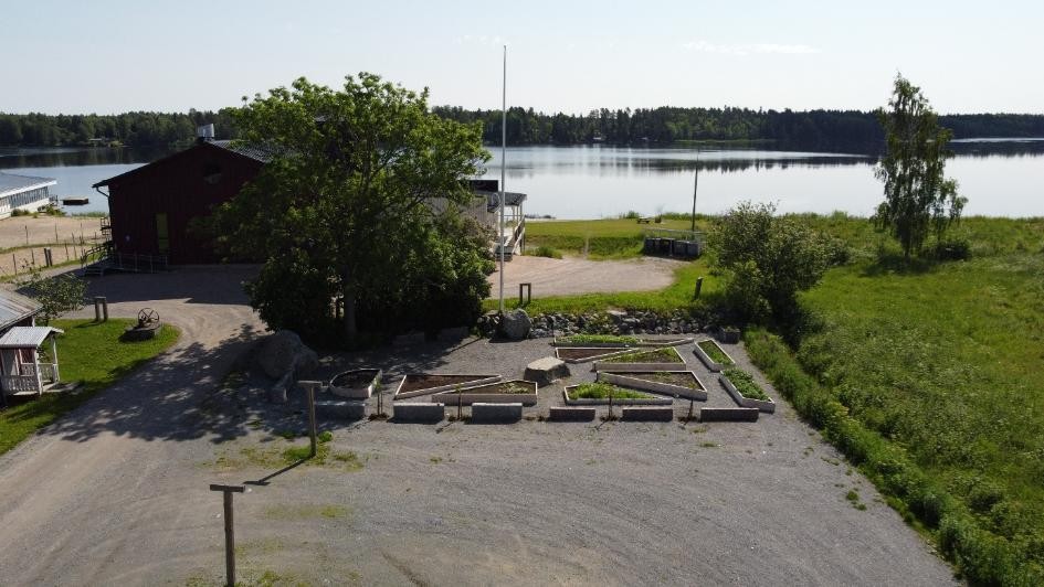 del av skolgård som byggts om till skolträdgård med odlingslådor