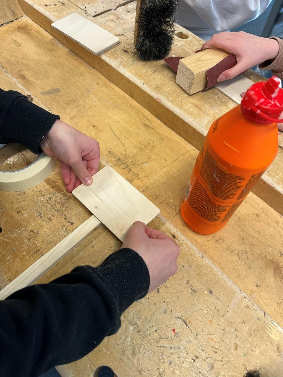 En slöjdbänk där ett barn bygger en skylt till odlingslåda