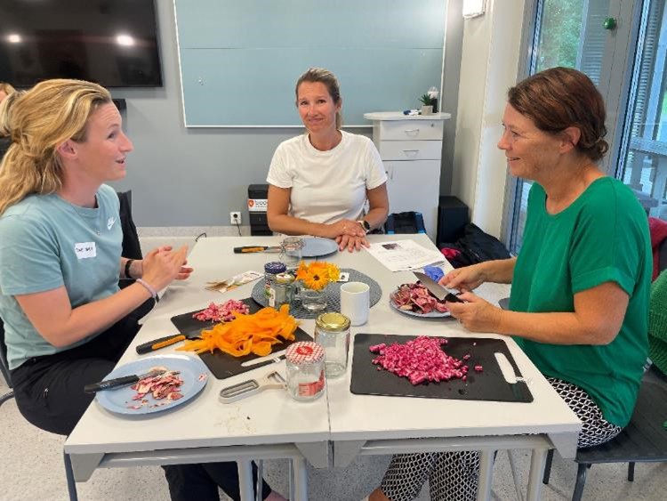 tre kvinnor arbetar med konservering av grönsaker