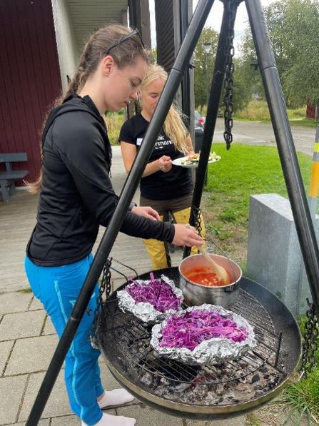Två kvinnor lagar mat på muurikka