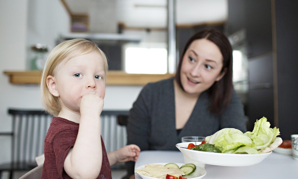 Barn äter med vuxen