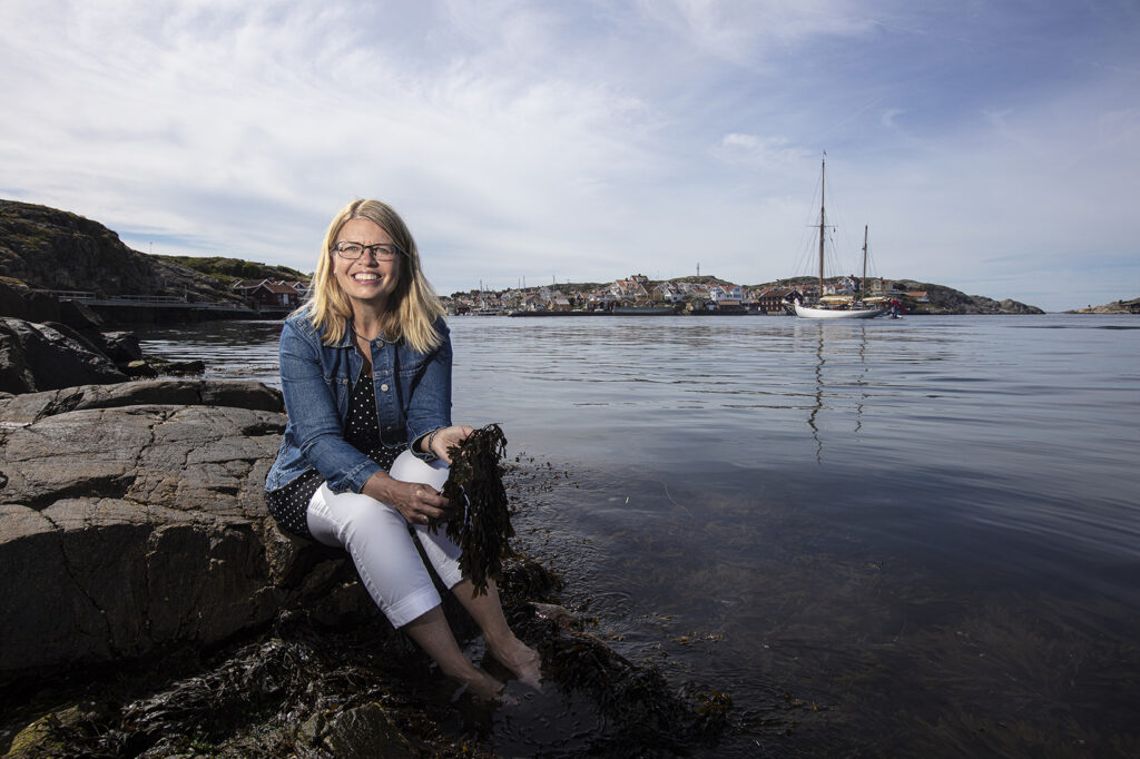 Lillemor Lindberg sitter på en klippa vid havet