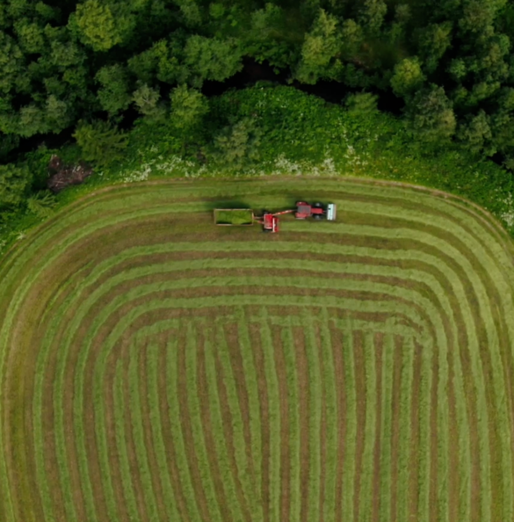 En traktor som kör på en åker, fotad uppifrån