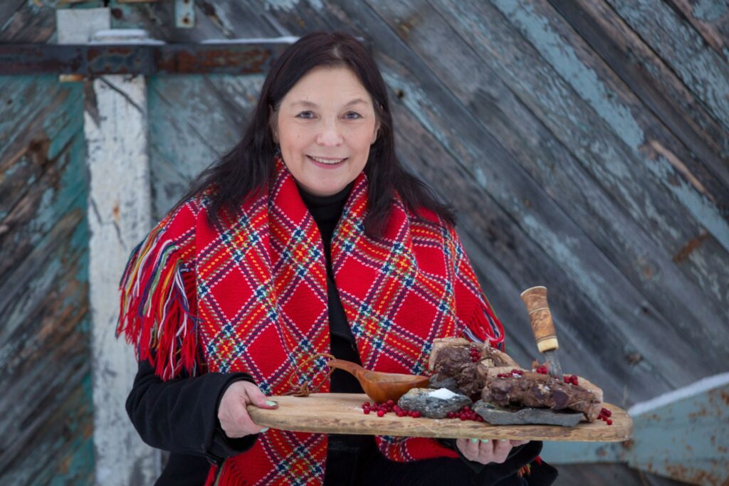 Victoria Harnesk håller upp en skärbräda med renkött på